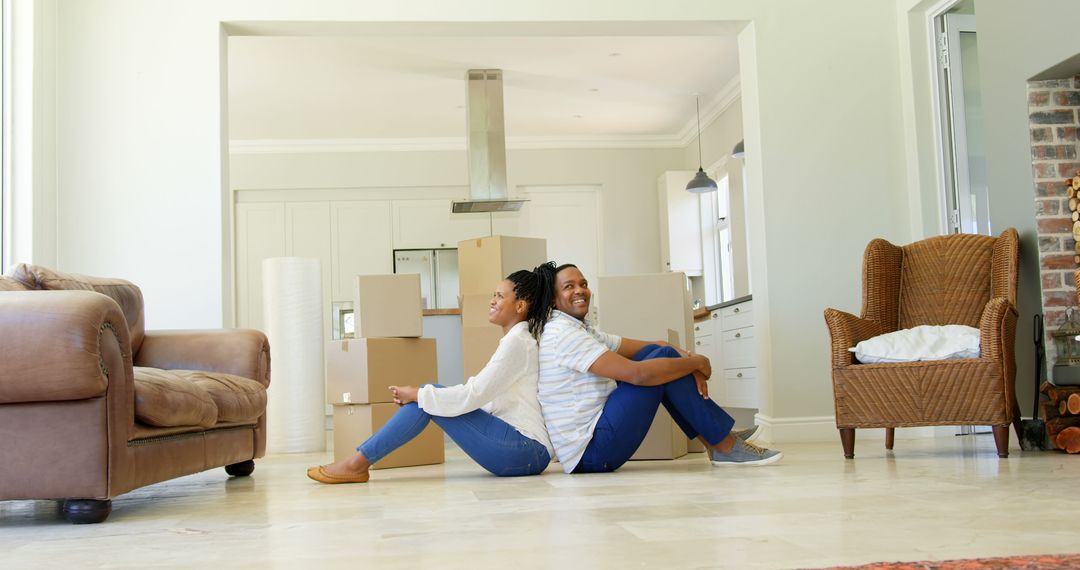 Happy Couple Relaxing Amidst Moving Boxes at New Home