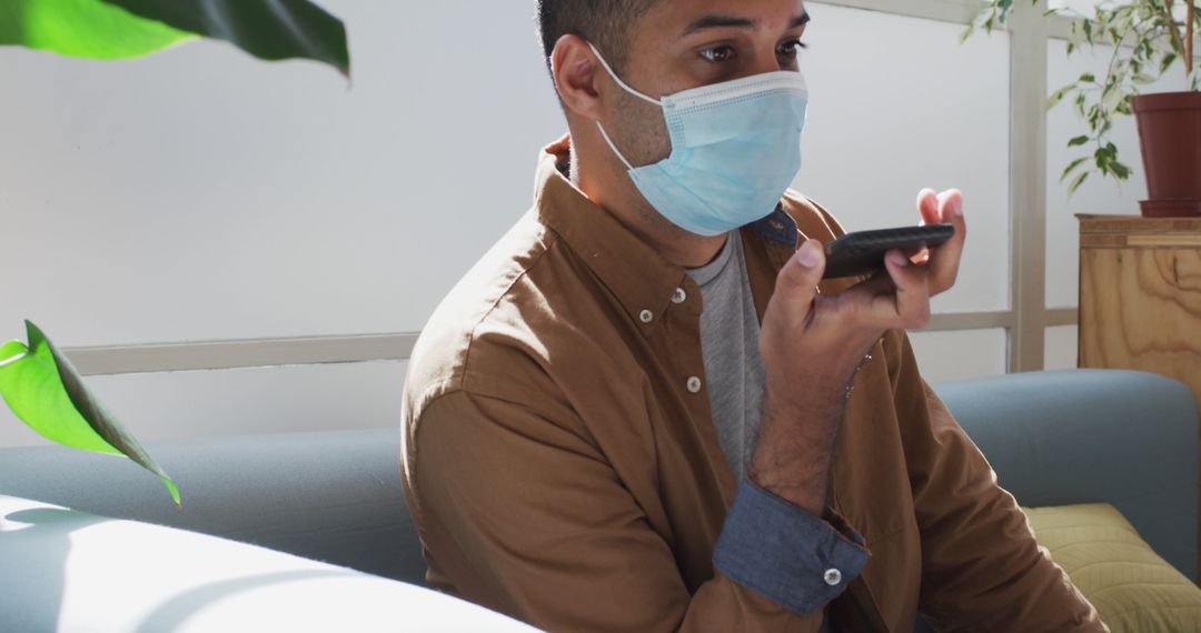 Man with Face Mask Using Smartphone Voice Assistant in Office - Free Images, Stock Photos and Pictures on Pikwizard.com