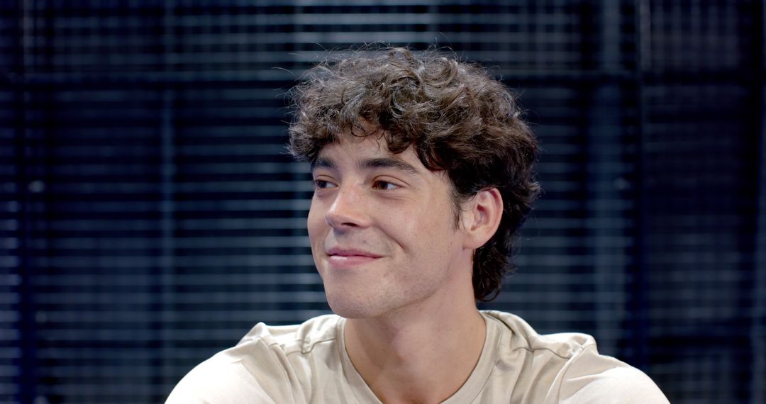 Smiling Man in Studio with Dark Slat Background