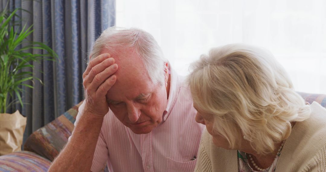 Senior Couple Discussing Papers at Home During Social Distancing