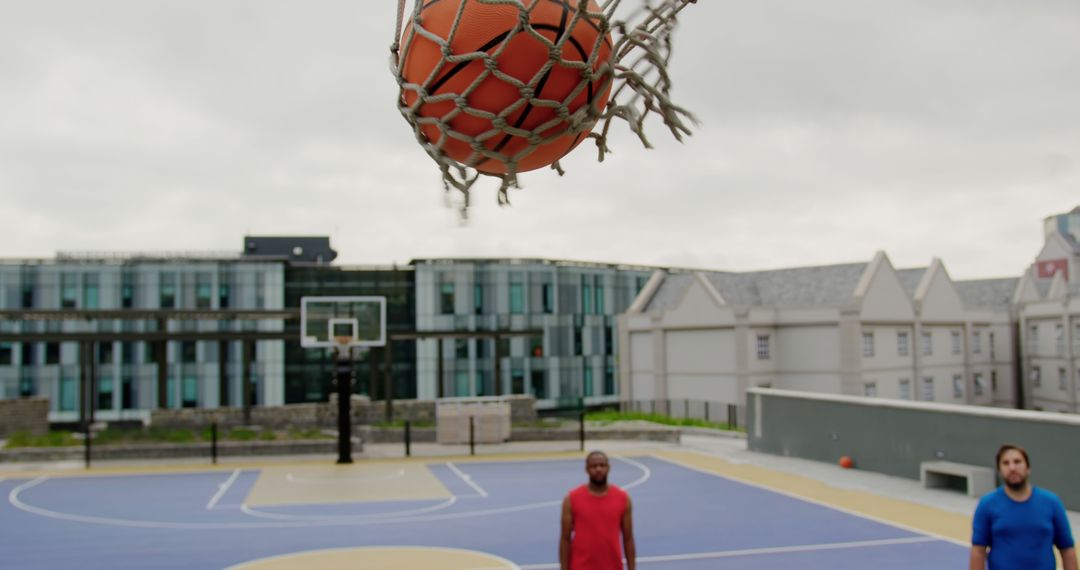 High-Angle View of Basketball Going through Hoop on Outdoor Court - Free Images, Stock Photos and Pictures on Pikwizard.com