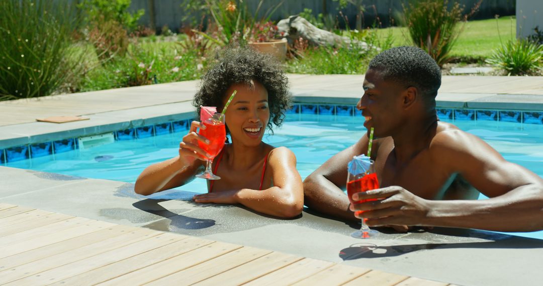Front view of young black couple toasting glasses of cocktail in the swimming pool at resort - Free Images, Stock Photos and Pictures on Pikwizard.com