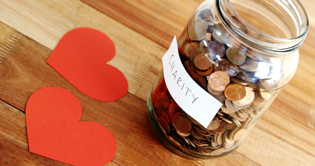 Charity Donation Jar with Coins and Paper Hearts on Wooden Table - Free Images, Stock Photos and Pictures on Pikwizard.com