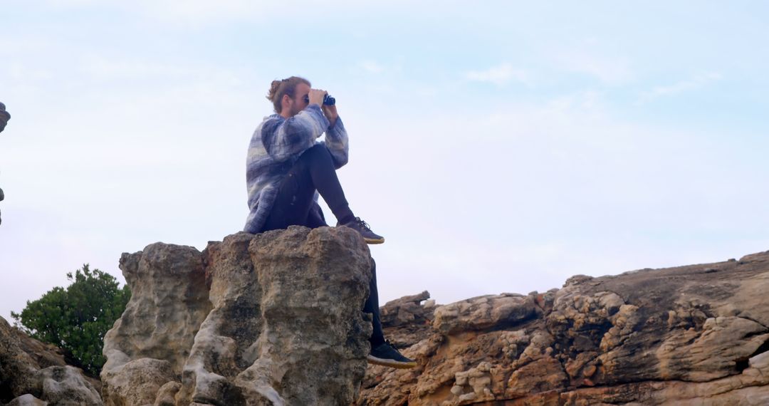 Woman Exploring Rocks with Binoculars in Outdoor Adventure - Free Images, Stock Photos and Pictures on Pikwizard.com