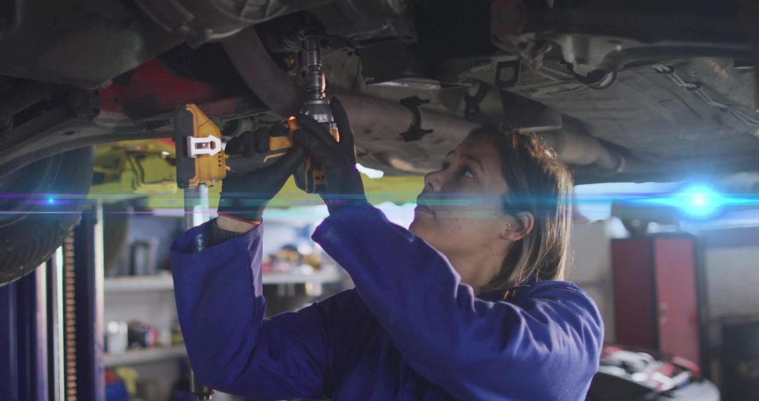 Female Mechanic Using Impact Wrench in Automotive Workshop