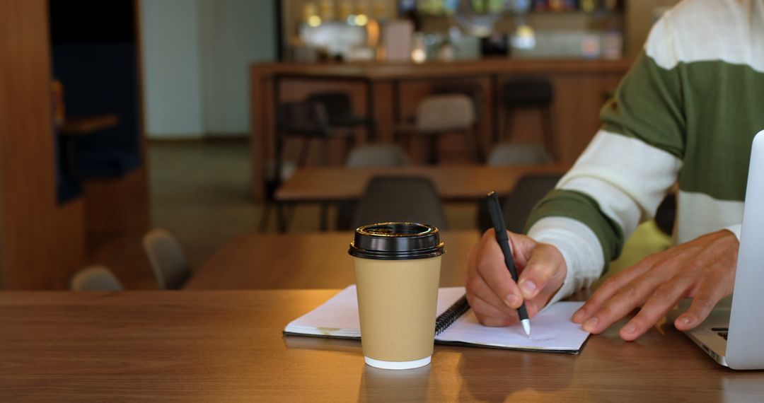 Man Writing in Notebook by Coffee in Modern Cafe - Free Images, Stock Photos and Pictures on Pikwizard.com