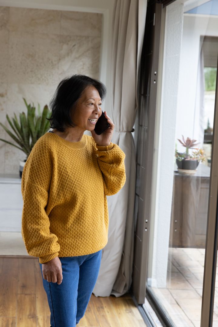 Senior Woman Enjoying Phone Call by Sunlit Window