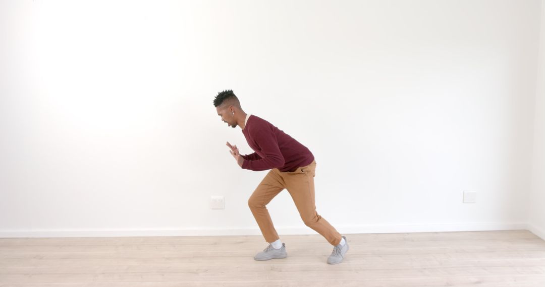 Young Man Practicing Dance Moves in Empty Room