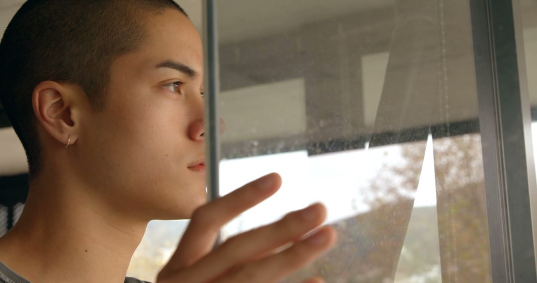 Young Man Contemplating Outside Through Window - Free Images, Stock Photos and Pictures on Pikwizard.com