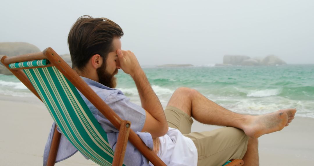 Contemplating Man Relaxing on Beach in Tranquil Seaside Setting