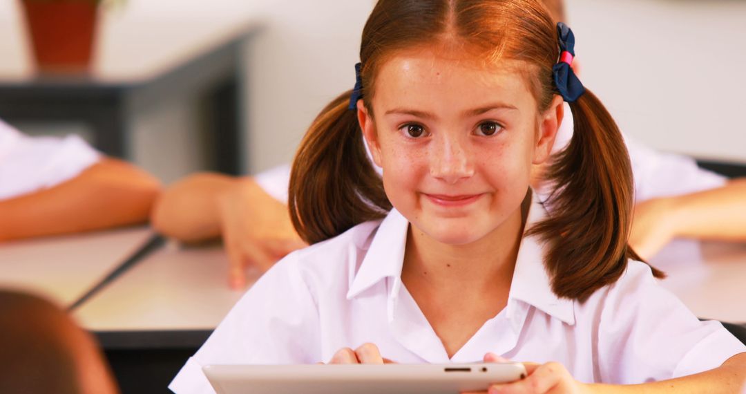 Smiling Schoolgirl Using Tablet in Classroom - Free Images, Stock Photos and Pictures on Pikwizard.com