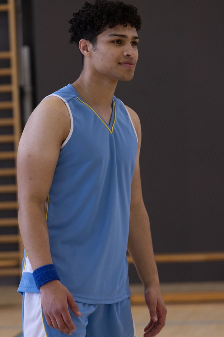 Confident Male Athlete in Blue Basketball Gear on Indoor Court