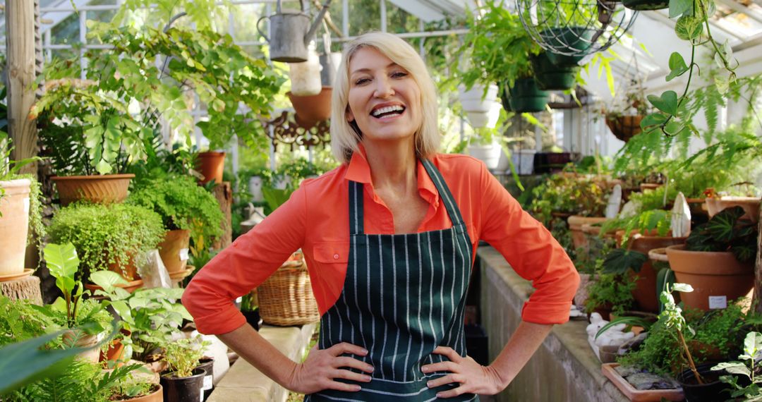 Smiling Woman in Greenhouse Surrounded by Plants - Free Images, Stock Photos and Pictures on Pikwizard.com