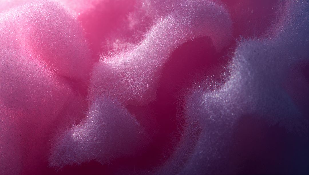 Macro cotton candy texture showing fluffy pink fibers, delicate filaments and soft gradient light