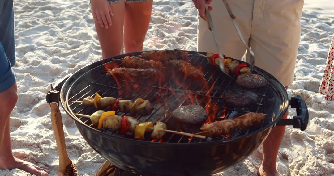 Friends Grilling Food on a Beach Barbecue - Free Images, Stock Photos and Pictures on Pikwizard.com