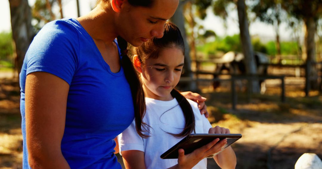 Mother and Daughter Exploring Digital Tablet Outdoors Together - Free Images, Stock Photos and Pictures on Pikwizard.com