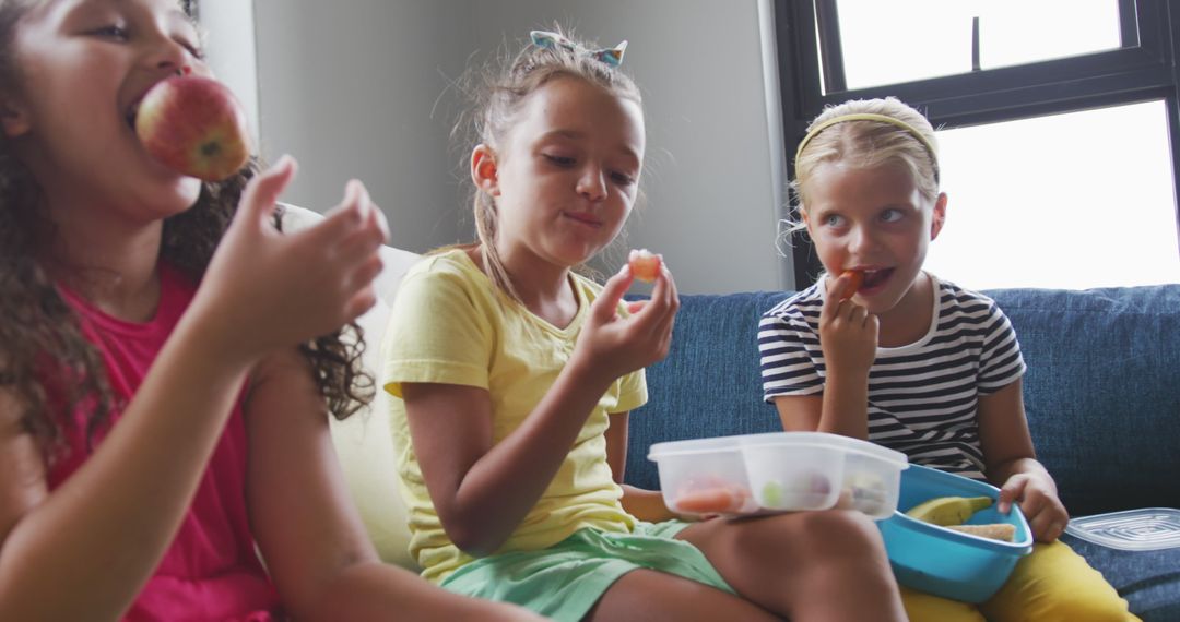 Happy diverse school girls enjoying lunch together