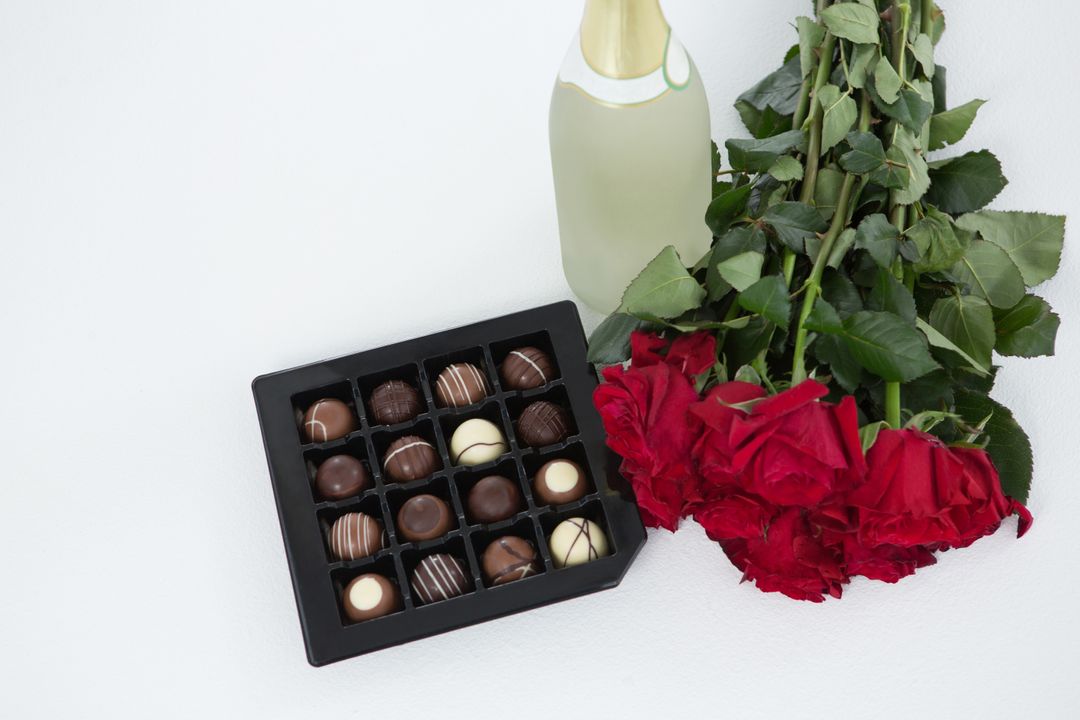 Gift, chocolate box, roses and champagne bottle on white background - Free Images, Stock Photos and Pictures on Pikwizard.com