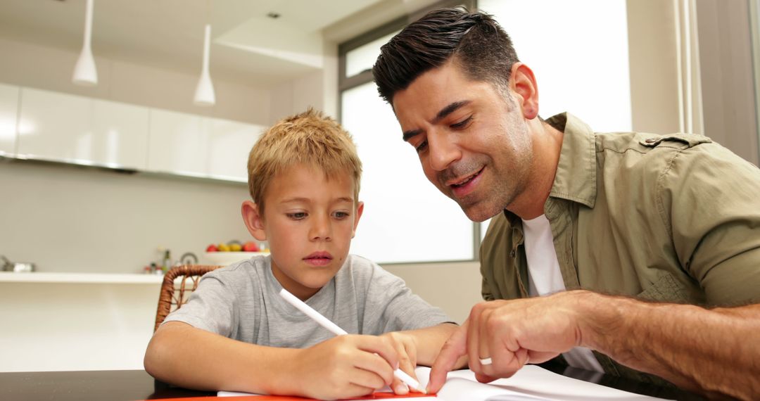 Father and Son Drawing Together at Home on Kitchen Table in Cozy Setting - Free Images, Stock Photos and Pictures on Pikwizard.com