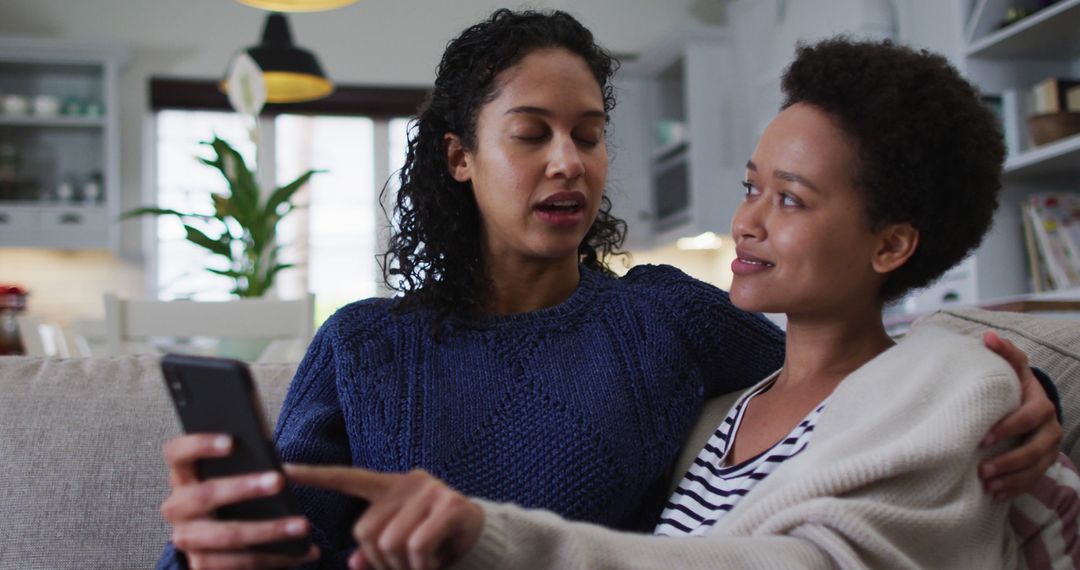 Couple Embracing on Couch Using Smartphone During Pandemic