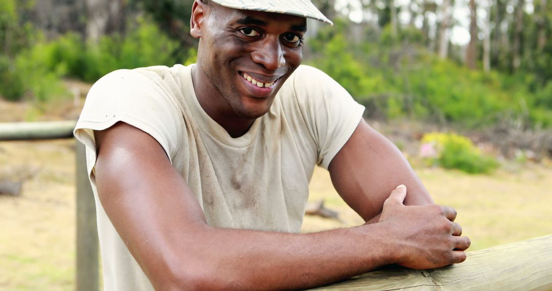 Smiling African American Man Leaning on Fence Post in Outdoor Setting - Free Images, Stock Photos and Pictures on Pikwizard.com