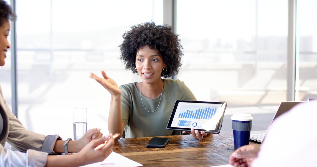 Diverse Coworkers Analyzing Data on Tablet in Modern Office
