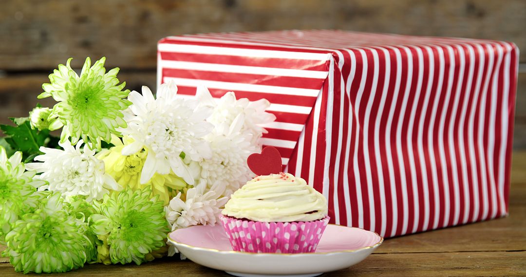 Cupcake with Heart Topper and Gift Box Surrounded by Flowers - Free Images, Stock Photos and Pictures on Pikwizard.com