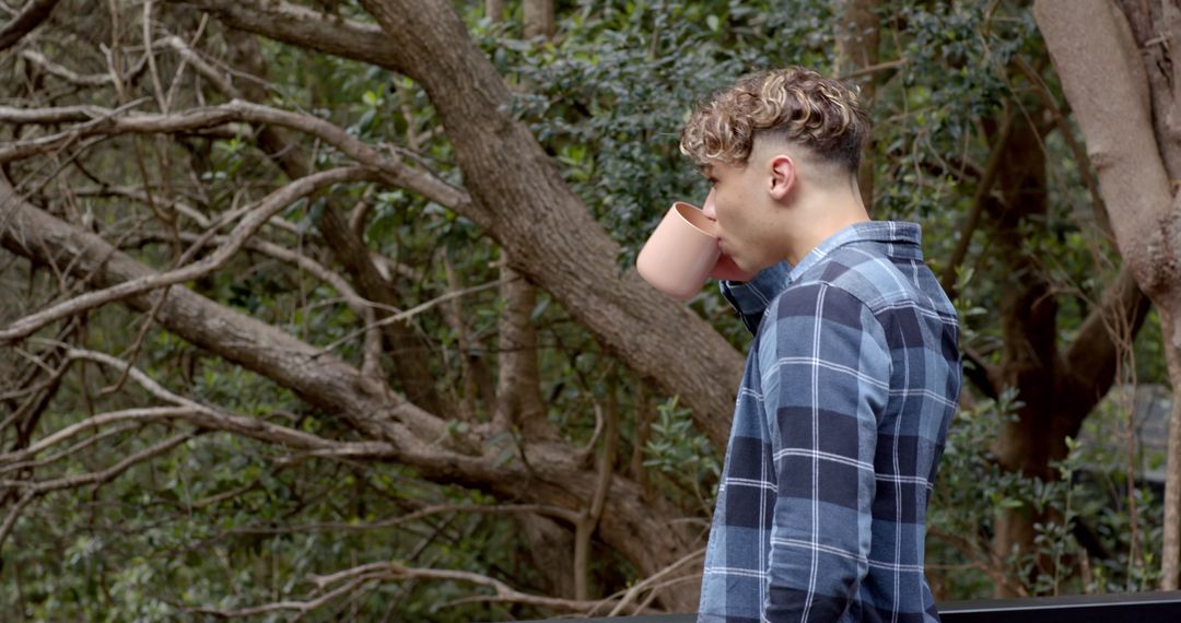 Man Enjoying Nature with a Cup of Coffee in Serene Forest