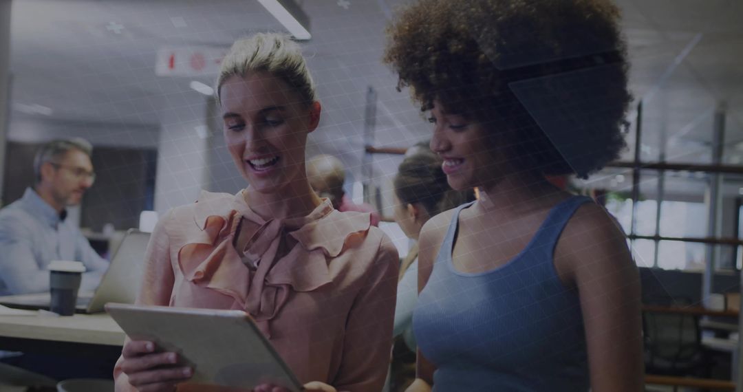 Smiling Coworkers Collaborating Over Tablet in Modern Open-Plan Office During Team Discussion
