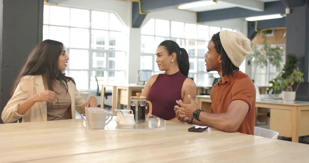 Diverse team discussing ideas over coffee in modern open-plan coworking hub