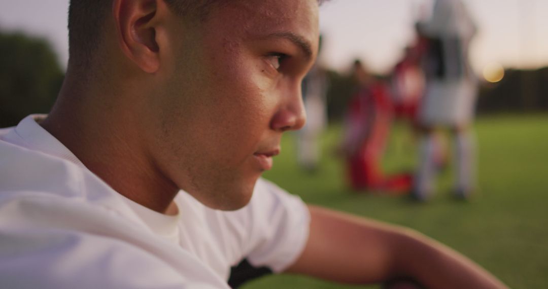 Image of sad biracial football player siting on field - Free Images, Stock Photos and Pictures on Pikwizard.com