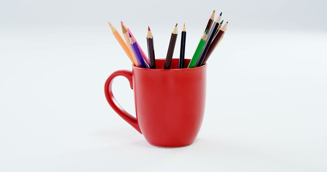 The red mug with colored pencils against a white backdrop symbolizes artistic inspiration. - Free Images, Stock Photos and Pictures on Pikwizard.com