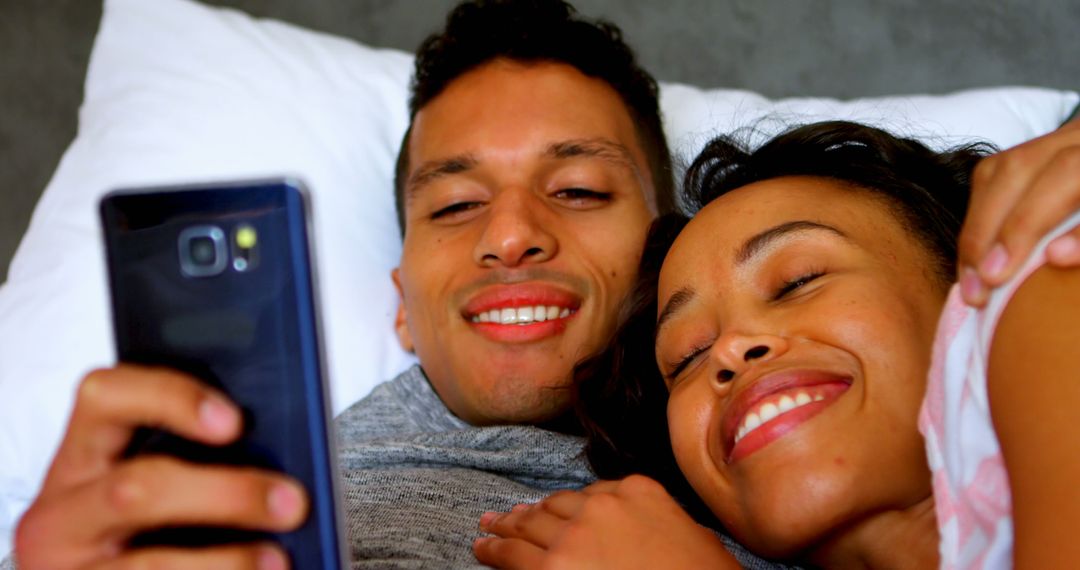 Joyful Couple Relaxing Together Taking Selfie in Bed