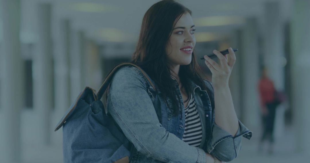 Young Woman Using Smartphone Microphone in Urban Transit Environment