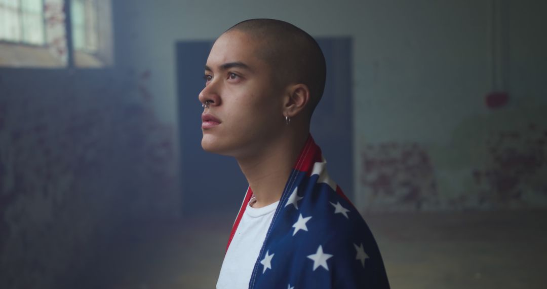 Young Man in Industrial Space Wrapped in American Flag - Free Images, Stock Photos and Pictures on Pikwizard.com