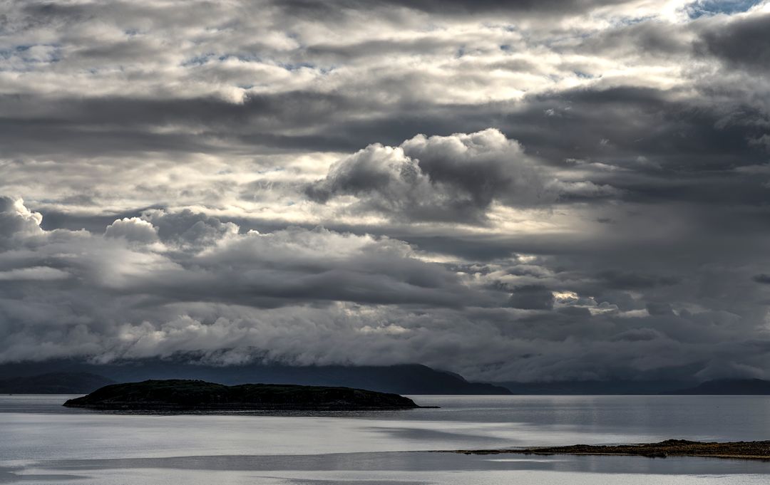 Dramatic Cloudscape Over Serene Island and Calm Waters - Free Images, Stock Photos and Pictures on Pikwizard.com