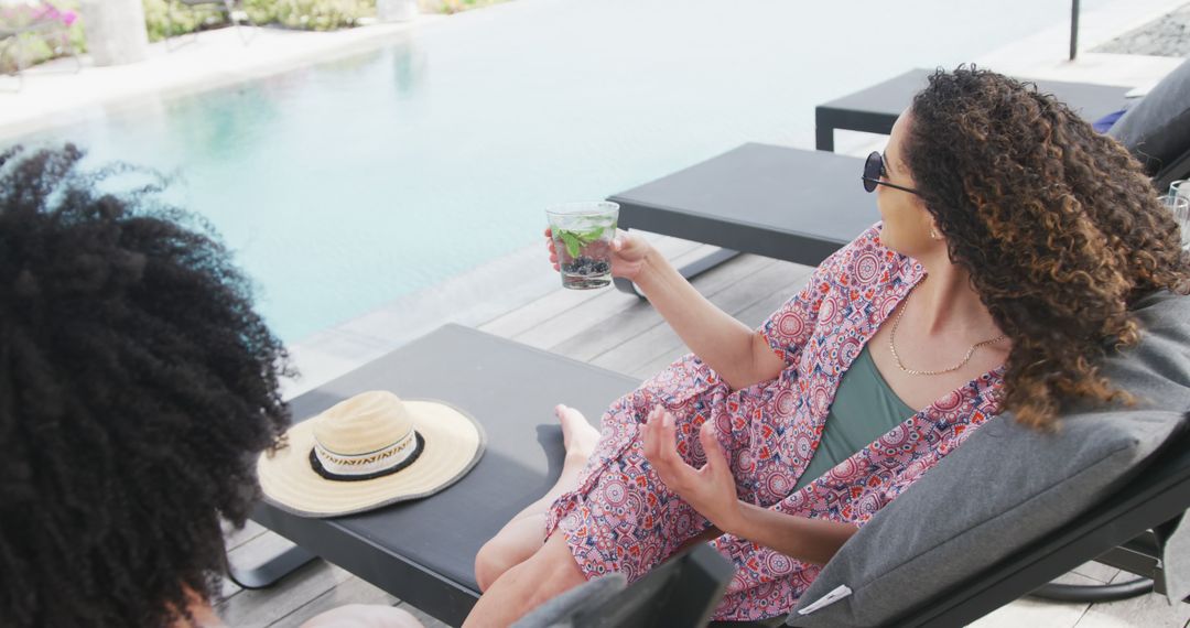 Women Relaxing Poolside Holding Drink at Luxury Resort - Free Images, Stock Photos and Pictures on Pikwizard.com