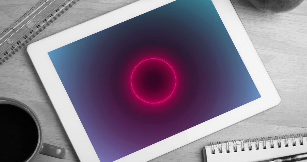 Tablet Screen Displaying Neon Circles on Wooden Desk