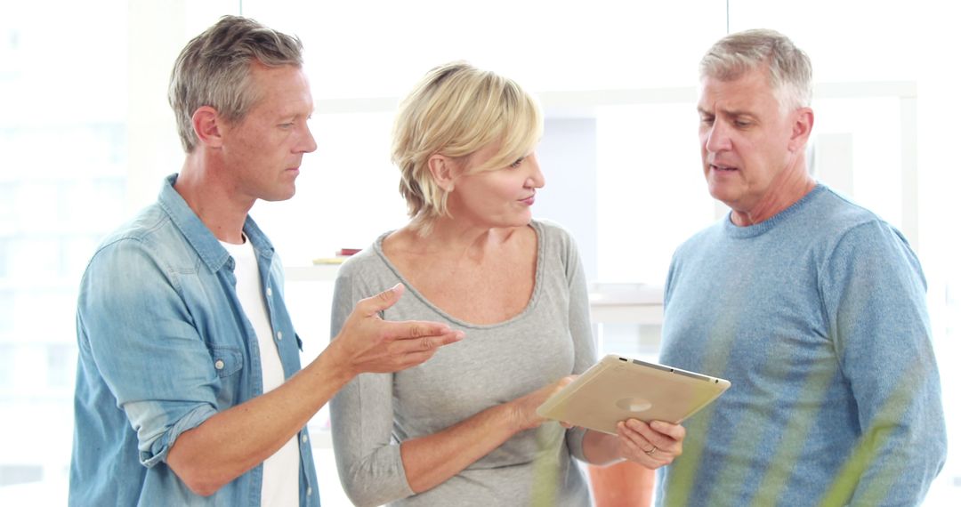 Middle-aged Caucasian Professionals Collaborating with Tablet