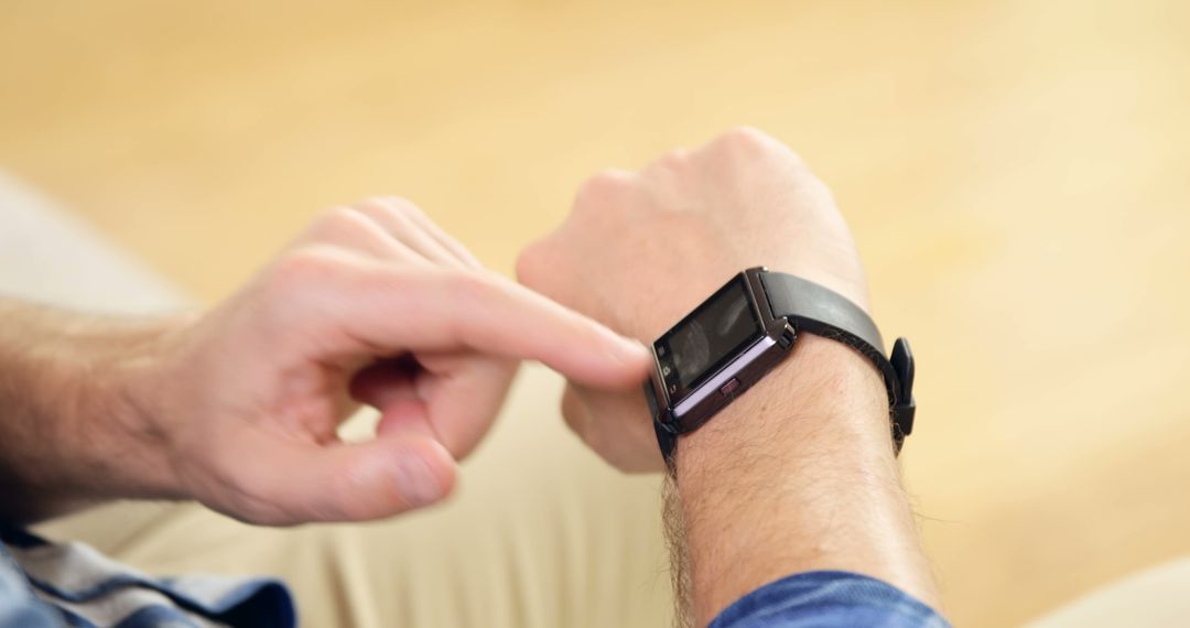 Man checking smartwatch for notifications indoors - Free Images, Stock Photos and Pictures on Pikwizard.com