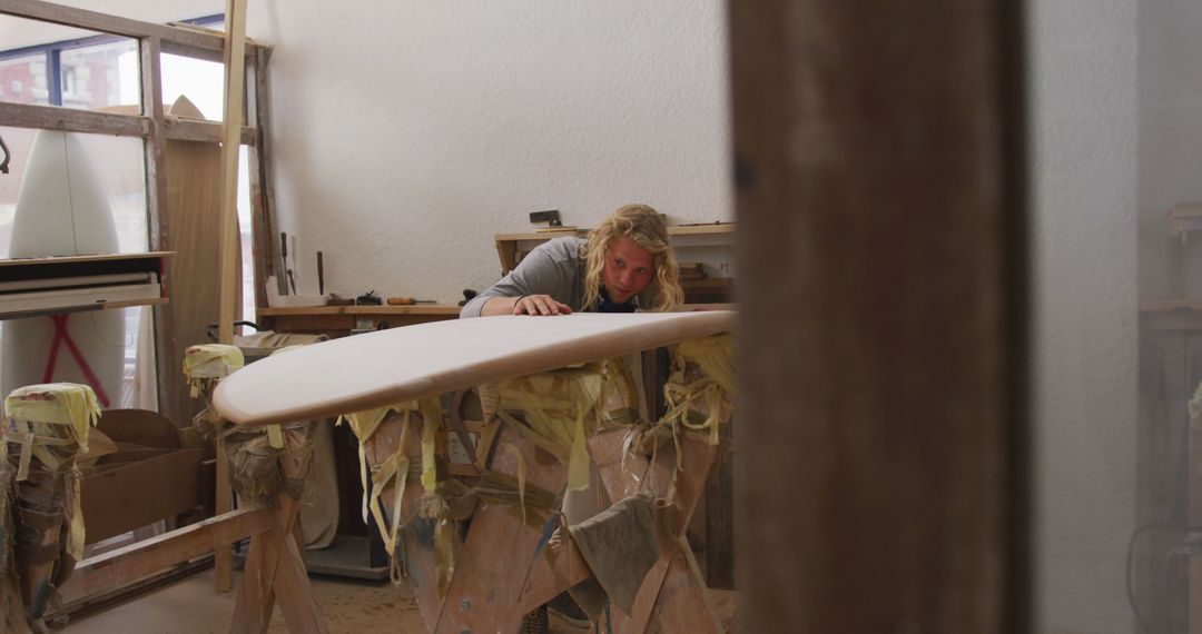 Craftsperson Shaping Surfboard in Workshop - Free Images, Stock Photos and Pictures on Pikwizard.com