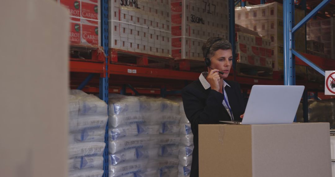 Warehouse Manager Communicating Over Headset While Using Laptop - Free Images, Stock Photos and Pictures on Pikwizard.com