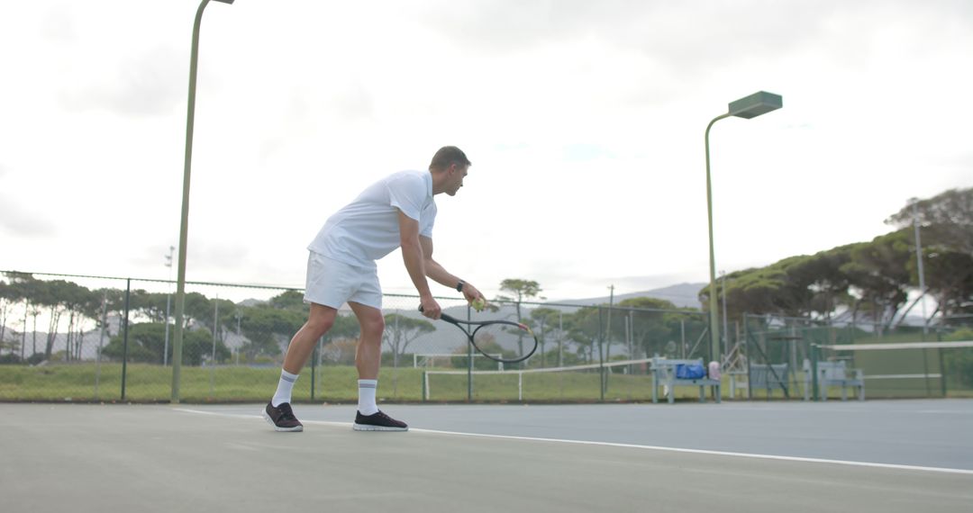 Male Tennis Player Practicing Serve on Outdoor Tennis Court - Free Images, Stock Photos and Pictures on Pikwizard.com