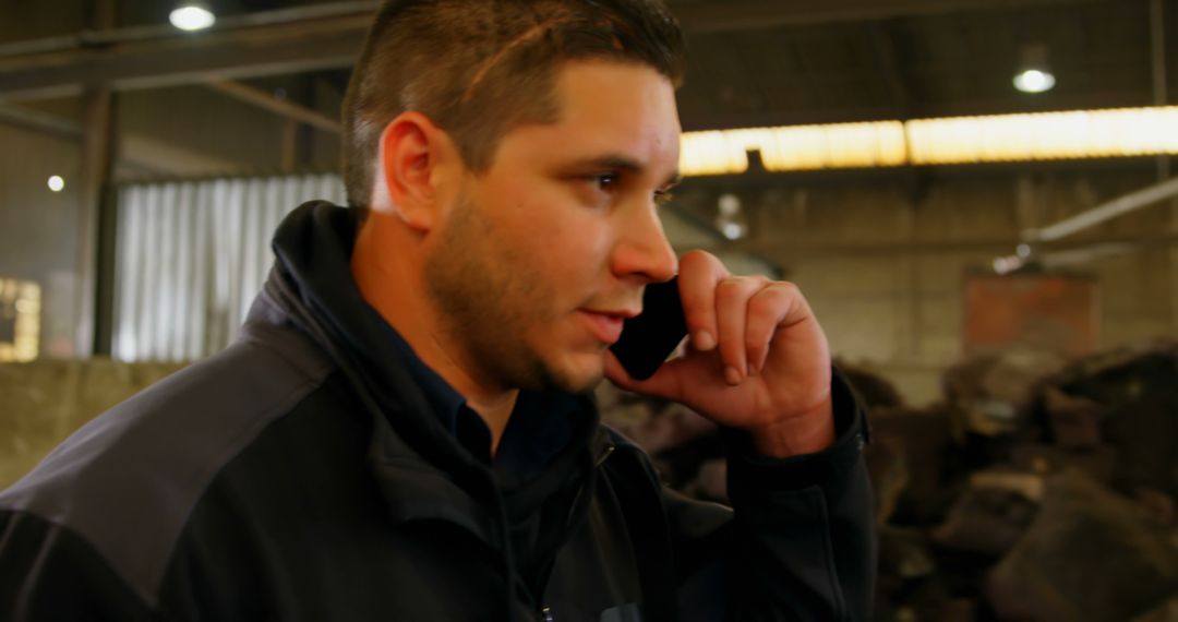 Male factory worker talking on phone in industrial warehouse - Free Images, Stock Photos and Pictures on Pikwizard.com