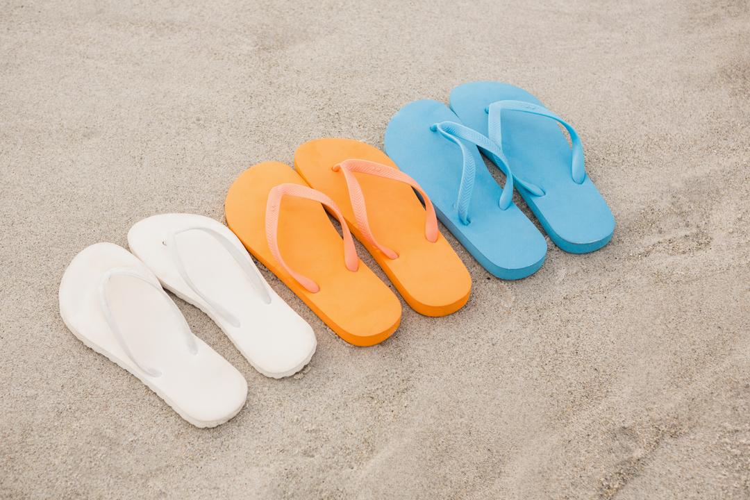 Multi-color flip flops arranged in a row in sand - Free Images, Stock Photos and Pictures on Pikwizard.com