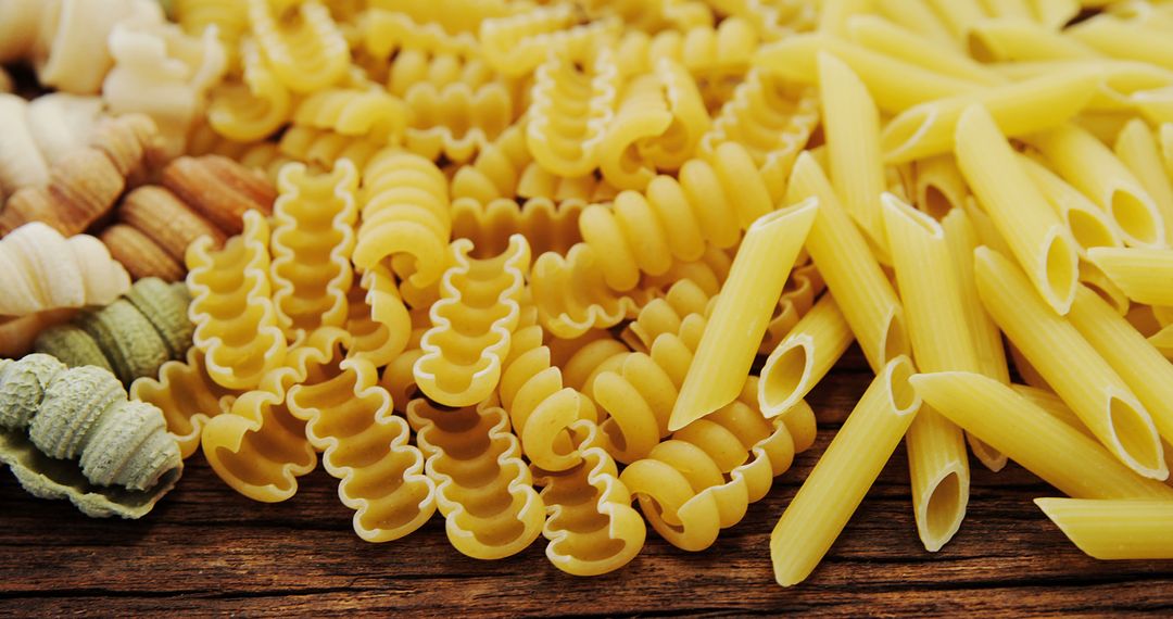 Assorted Uncooked Pasta on Wooden Table - Free Images, Stock Photos and Pictures on Pikwizard.com