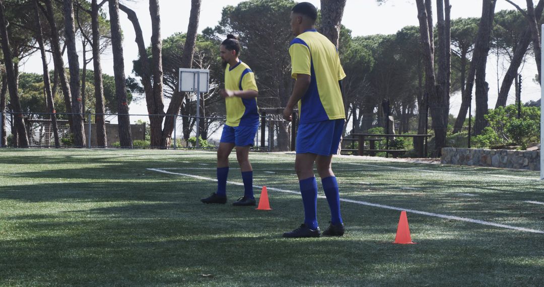 Soccer Players Practicing Agility Drills on Field with Cones