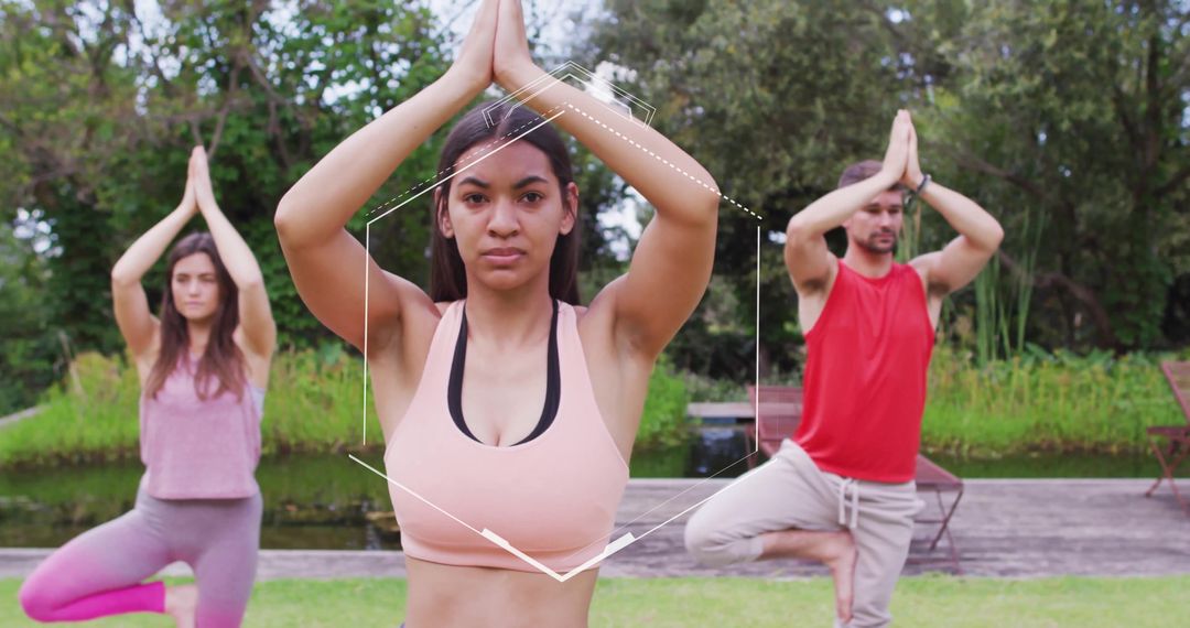 Group Performing Yoga Tree Pose in Tranquil Outdoor Setting