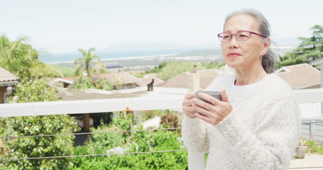 Senior Woman Relaxing with Coffee on Balcony Overlooking Scenic Landscape - Free Images, Stock Photos and Pictures on Pikwizard.com