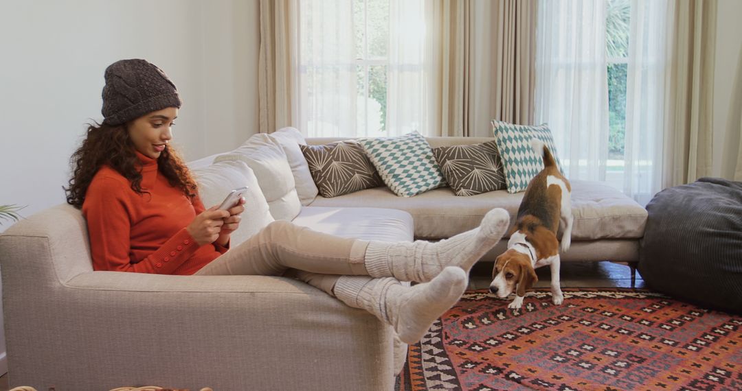 Woman Relaxing on Couch with Mobile Phone and Curious Dog at Home - Free Images, Stock Photos and Pictures on Pikwizard.com